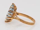 a close up of a gold ring with a blue topaz stone