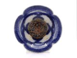 a small blue and white plate with a flower on it
