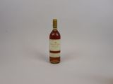 une photo d'une bouteille de vin posée sur une surface blanche