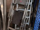une pile de chaises et une échelle dans une pièce