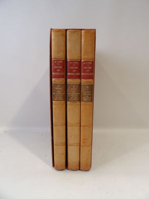 trois livres sont empilés sur une surface blanche