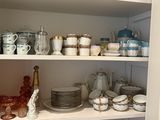 many dishes and glasses on the shelves in the kitchen