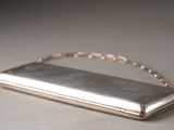 a silver purse that is sitting on a table