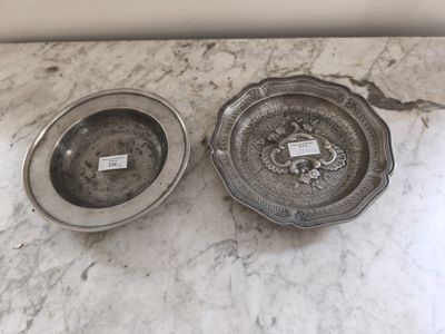 deux plats en argent posés sur un plan de travail en marbre
