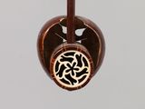 a wooden pendant with a celtic design hanging from it ' s neck