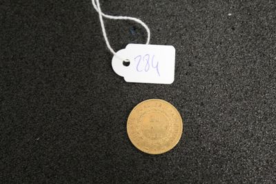 une pièce d'or à laquelle est attachée une étiquette de prix