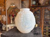a white vase sitting on top of a wooden table