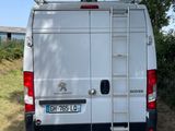 the back end of a white van parked on a dirt road