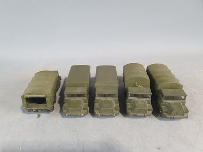 six army trucks lined up in a row on a white surface