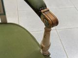 une chaise verte avec une assise verte et un accoudoir en bois