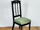 a black chair with a green seat on a parquet floor
