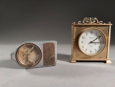 two clocks sitting next to each other on a table