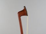 a close up of a violin bow on a table with a gray background