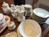 a wooden table with a lot of dishes and cups on it