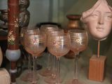 many wine glasses that are sitting on a shelf
