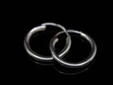 pair of silver hoop earrings on a black surface
