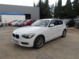 a white bmw car parked in a parking lot