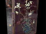 une armoire sur laquelle sont peintes des fleurs sur fond noir