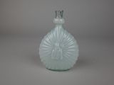 a green glass bottle with a decorative design on it
