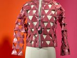 pink leather jacket on a mannequin mannequin with a red background