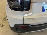 the rear end of a white car with a sticker on it ' s bumper