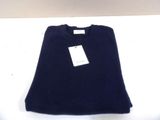 navy blue sweater with white tag on white table