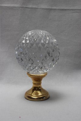une image représentant une poignée de porte en verre montée sur un support doré