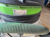 a green and black vacuum sitting on top of a cart