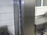 un réfrigérateur en acier inoxydable dans une cuisine équipée d'un évier et d'une cuisinière