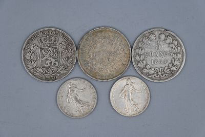 six pièces de monnaie britanniques différentes sont disposées en rangée sur un fond bleu