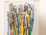 several toothbrushes are in a clear display case on a table