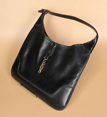 un sac à main noir muni d'une chaîne suspendue à la poignée