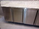 a stainless steel refrigerator and a granite counter in a kitchen
