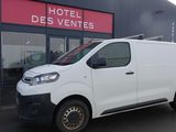 une camionnette blanche garée devant un bâtiment dans un parking