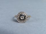 a close up of a ring with a black and white diamond