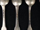 six spoons with chinese writing are lined up on a black surface