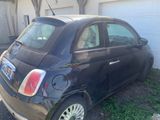 a small black car parked in front of a garage
