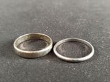two wedding rings sitting on top of each other on top of a table