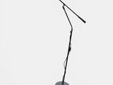 a black lamp that is on the ground next to a pair of headphones