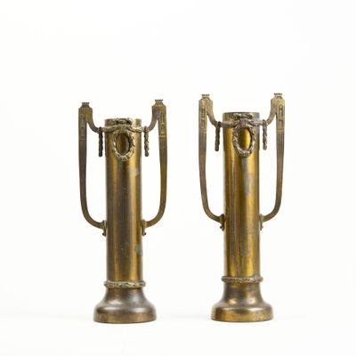 two metal vases that have handles on them
