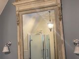 a large mirror above a sink in a bathroom