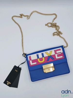 a close up of a blue purse with a gold chain