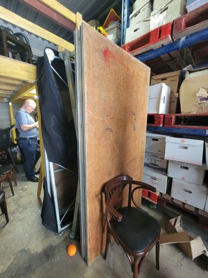 un homme debout dans une pièce où se trouve une chaise