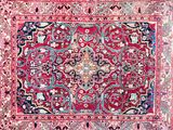 an antique persian rug with red and blue colors