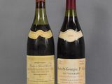 two bottles of wine sitting on top of a table next to each other