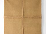 a piece of brown paper folded in four squares on a white surface