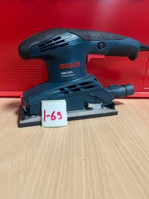 une ponceuse orbitale Bosch posée sur une table, avec son étiquette de prix