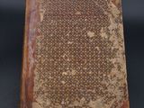 an old book sitting on top of a table covered in dirt