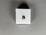 a close up of a small diamond on a white surface