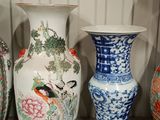 several vases are lined up on a shelf in a room